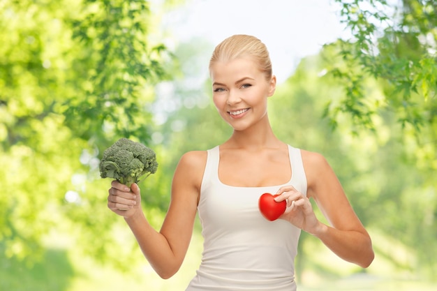 Photo happy smiling young woman with heart and broccoli