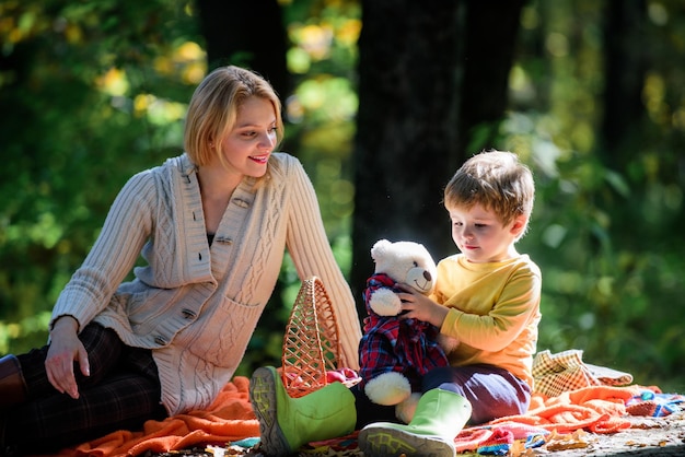 Happy son with mother relax in autumn forest Sunny weather Healthy food Mother love small child Spring mood Happy family day Family picnic Mothers day Spring in my head Spring easter holiday