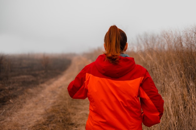 Happy sportive woman exercising outdoors in nature in the morning autumn forest path