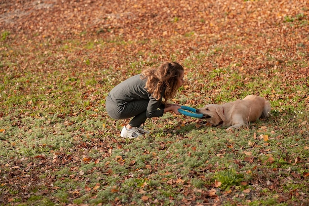 Happy sporty woman rest with her dog golden retriever Female athlete enjoying outdoor with her pet woman is training outside during autumn