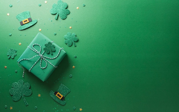 Happy St Patrick's Day decoration concept made from shamrocks clover leaf gift box and leprechaun hat on green background