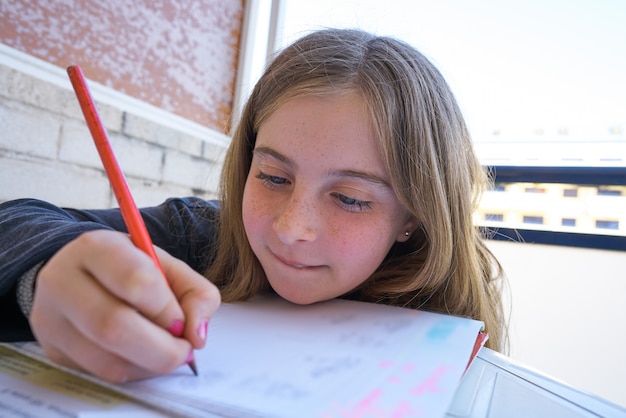 Happy student girl doing her homework