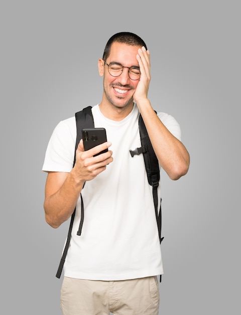 Happy student using his mobile phone