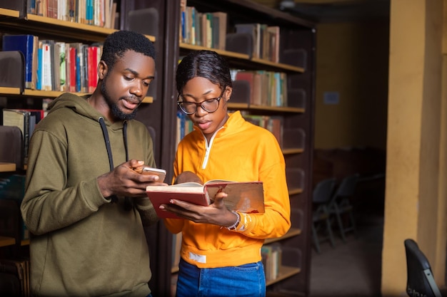 Happy students couple in school studying for exams together