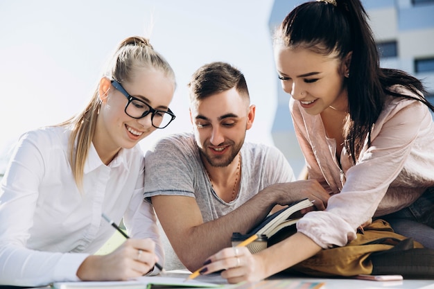 Happy students work and study at the table on fresh air