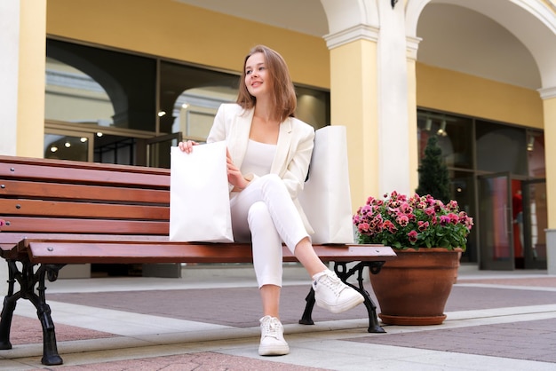 happy stylish girl young beautiful woman in mall during shopping carrying shopping paper bag