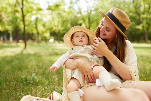 Happy stylish and loving family. mother playing with her baby outdoor. lovely baby smiles and enjoys. Mother's day concept.