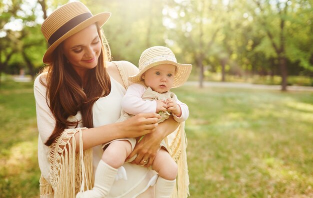 Happy stylish and loving family. mother playing with her baby outdoor. lovely baby smiles and enjoys. Mother's day concept.