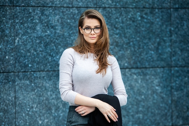 Happy successful professional woman posing near office building