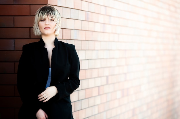 Happy successful woman professional posing near office building