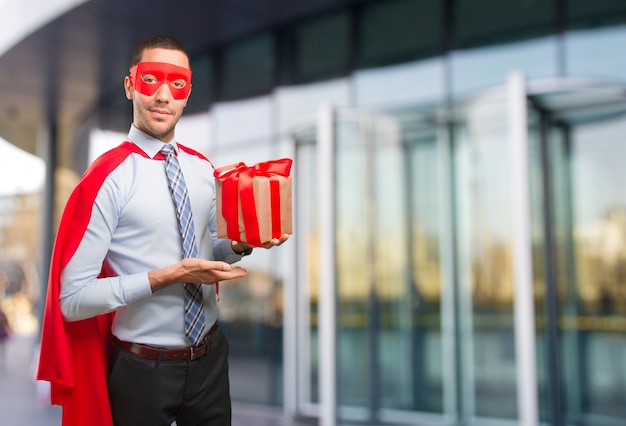 Happy super businessman with a gift