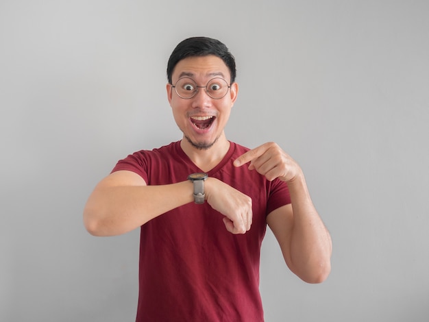 Happy and surprised Asian man who is looking at his watch.