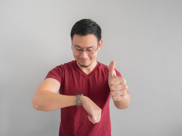 Happy and surprised Asian man who is looking at his watch.