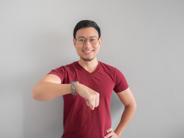 Happy and surprised Asian man who is looking at his watch.