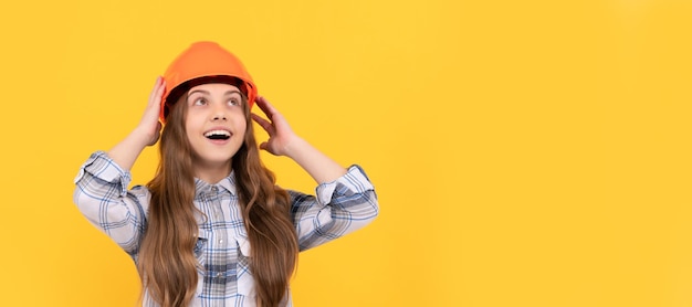 Happy teen girl in helmet and checkered shirt architect Child in hard hat horizontal poster design Banner header copy space