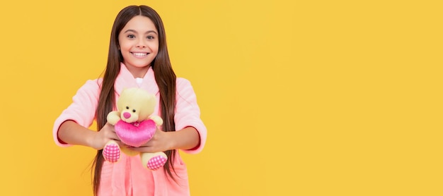 Happy teen girl in home terry bathrobe with toy toy Banner of child girl with toy studio portrait