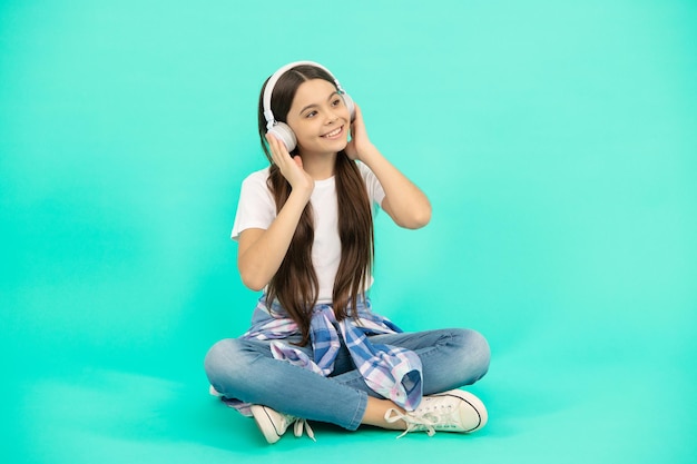 Happy teen girl listen to music in wireless headphones, childhood development.