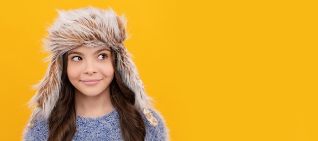 Happy teen girl wear earflap hat on yellow background portrait Child face horizontal poster teenager