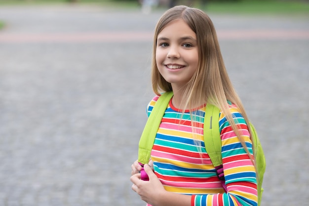 Happy teenage girl back to school outdoors copy space