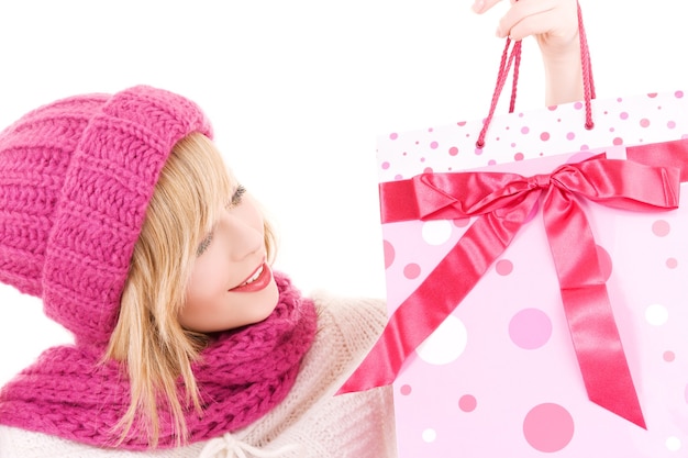 happy teenage girl in hat with pink shopping bags