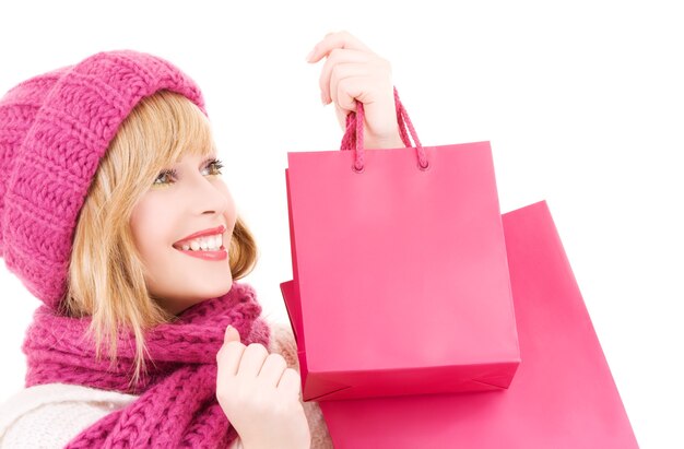 happy teenage girl in hat with pink shopping bags