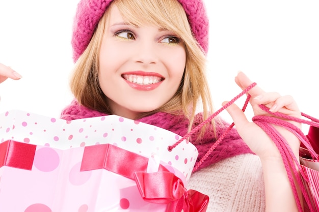 happy teenage girl in hat with pink shopping bags