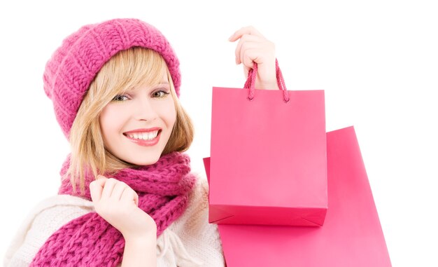 happy teenage girl in hat with pink shopping bags