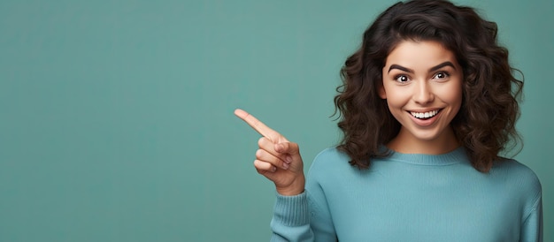 Happy teenage girl pointing and smiling drawing attention to an object in empty area