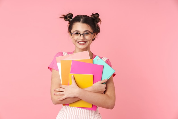 Happy teenage girl standing isolated, carrying textbooks