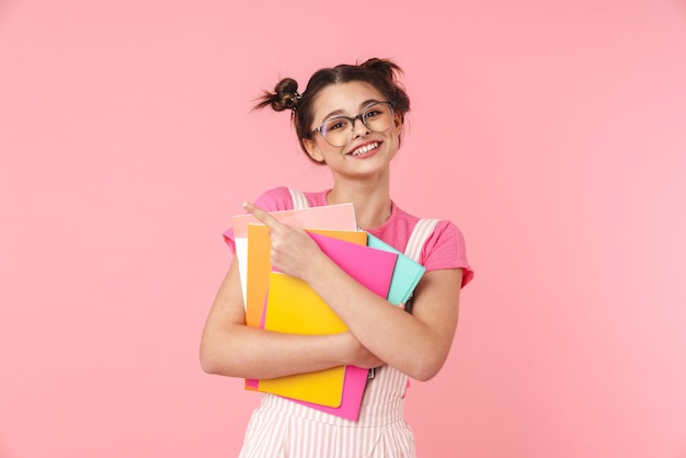 Happy teenage girl standing isolated, carrying textbooks