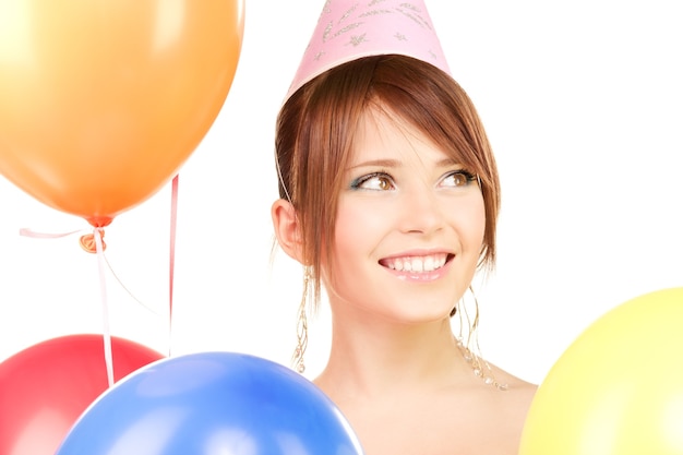 happy teenage party girl with balloons over white wall