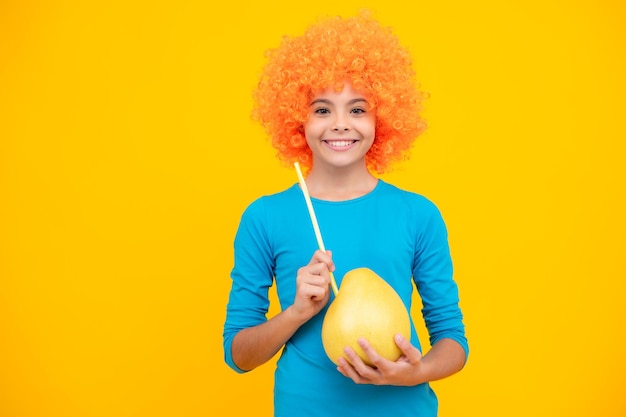 Happy teenager portrait Funny child girl in wig hold big citrus fruit  pomelo