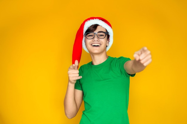 A happy teenager in a Santa hat on Christmas Eve