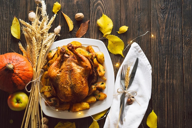 Happy Thanksgiving Autumn composition with leaves ripe pumpkin and Thanksgiving turkey on a dark wooden table Top view