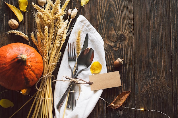 Happy Thanksgiving Autumn composition with leaves ripe pumpkin and Thanksgiving turkey on a dark wooden table Top view