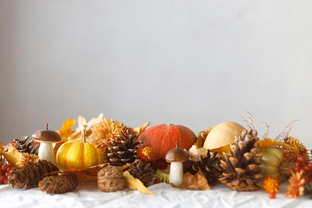 Happy Thanksgiving Pumpkins fall leaves and flowers berries mushroom and pine cones on linen cloth space for text Autumn banner Fall harvest background