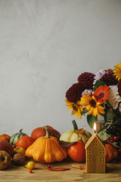 Happy Thanksgiving Stylish pumpkins autumn flowers berries leaves candle on rustic table