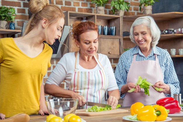 Happy three-generation family cooking together in kitchen