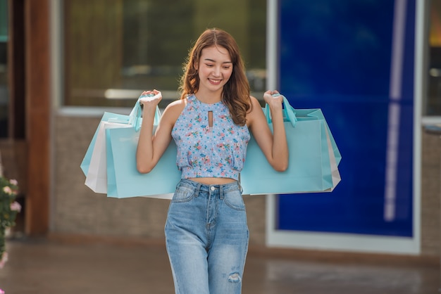 Happy time to shopping concept , Asian woman holding shopping bags at mall centre.