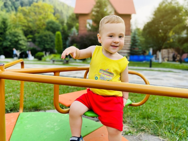 Happy toddler boy rides on a swing Indoor playground A cute boy of one and a half years Selective focus