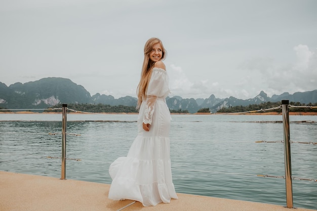 Happy travel girl fun on wooden pier with lake rainforest jungle and mountains