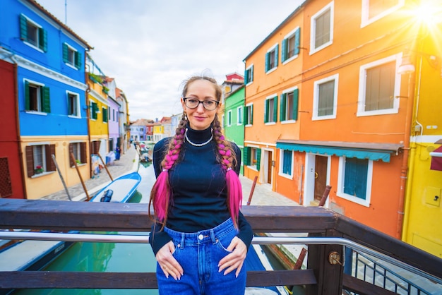 Happy traveler woman having fun near colorful houses on burano island in venetian lagoon travel and