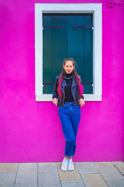 Happy traveler woman having fun near colorful houses on burano island in venetian lagoon travel and