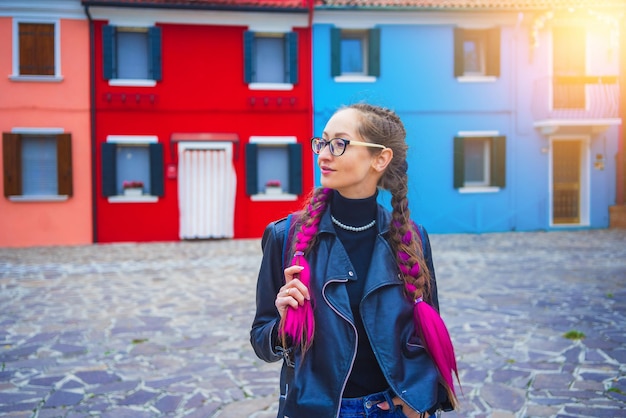 Happy traveler woman having fun near colorful houses on burano island in venetian lagoon travel and