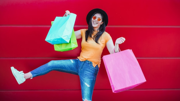 Happy trendy asian girl with shopping bags outdoor. Young woman having fun buying new clothes and accessories