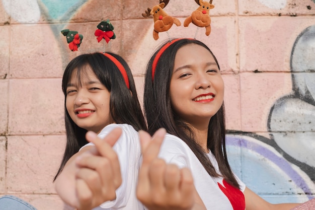 Photo happy two girl wear christmas hat on colorful background.