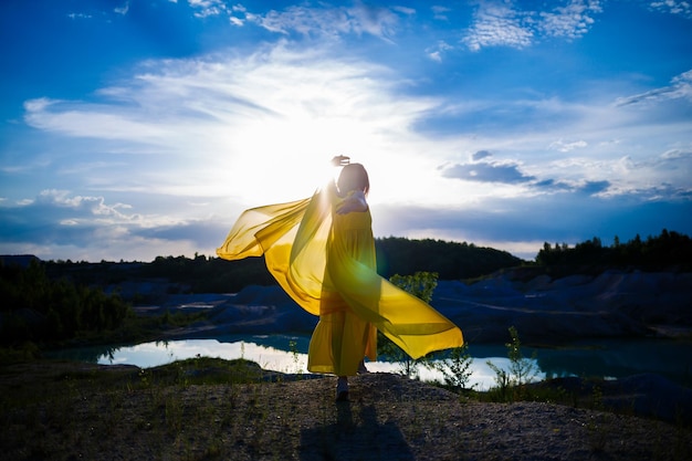 Happy Ukrainian woman running in nature In a long yellow dress Symbol of freedom of Ukraine Woman patriot of Ukraine Freedom peace without war selective focus