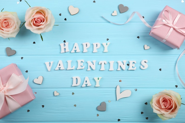 Happy Valentines day text with gifts and decorations on blue background