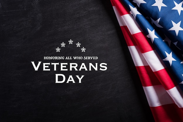 Happy Veterans Day. American flags against a blackboard background. 