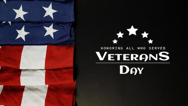 Happy Veterans Day. American flags with the text thank you veterans against a black background. November 11.